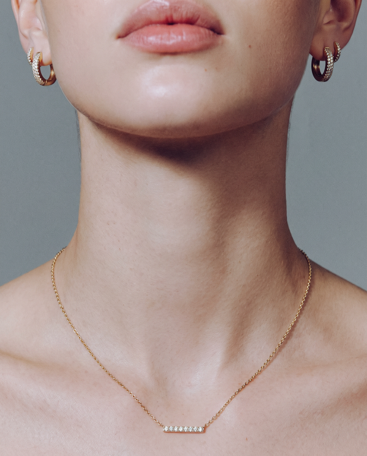 A close-up of a necklace worn at the neckline